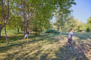 Baba ve kızı parkta birlikte zaman geçiriyorlar. Egzersiz yapıyor ve dinleniyorlar..