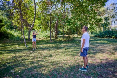 Baba ve kızı parkta birlikte zaman geçiriyorlar. Egzersiz yapıyor ve dinleniyorlar..