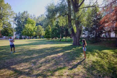 Baba ve kızı parkta birlikte zaman geçiriyorlar. Egzersiz yapıyor ve dinleniyorlar..