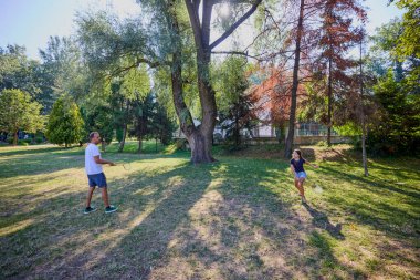 Baba ve kızı parkta birlikte zaman geçiriyorlar. Egzersiz yapıyor ve dinleniyorlar..