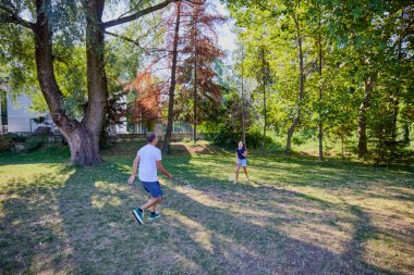 Baba ve kızı parkta birlikte zaman geçiriyorlar. Egzersiz yapıyor ve dinleniyorlar..
