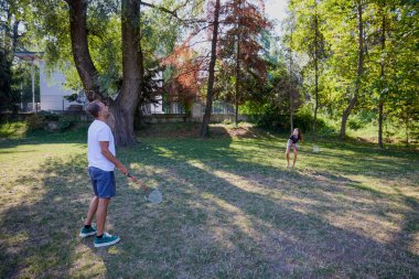 Baba ve kızı parkta birlikte zaman geçiriyorlar. Egzersiz yapıyor ve dinleniyorlar..