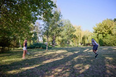 Baba ve kızı parkta birlikte zaman geçiriyorlar. Egzersiz yapıyor ve dinleniyorlar..