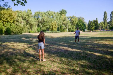 Baba ve kızı parkta birlikte zaman geçiriyorlar. Egzersiz yapıyor ve dinleniyorlar..