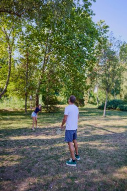Baba ve kızı parkta birlikte zaman geçiriyorlar. Egzersiz yapıyor ve dinleniyorlar..