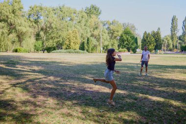 Baba ve kızı parkta birlikte zaman geçiriyorlar. Egzersiz yapıyor ve dinleniyorlar..