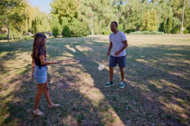 Baba ve kızı parkta birlikte zaman geçiriyorlar. Egzersiz yapıyor ve dinleniyorlar..