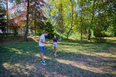 Baba ve kızı parkta birlikte zaman geçiriyorlar. Egzersiz yapıyor ve dinleniyorlar..