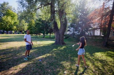 Baba ve kızı parkta birlikte zaman geçiriyorlar. Egzersiz yapıyor ve dinleniyorlar..