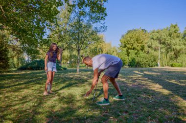 Baba ve kızı parkta birlikte zaman geçiriyorlar. Egzersiz yapıyor ve dinleniyorlar..