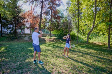 Baba ve kızı parkta birlikte zaman geçiriyorlar. Egzersiz yapıyor ve dinleniyorlar..
