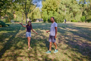 Baba ve kızı parkta birlikte zaman geçiriyorlar. Egzersiz yapıyor ve dinleniyorlar..