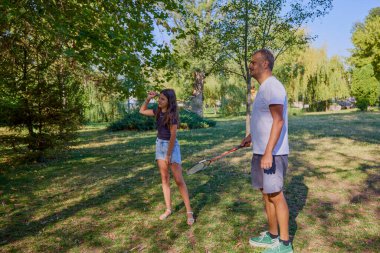 Baba ve kızı parkta birlikte zaman geçiriyorlar. Egzersiz yapıyor ve dinleniyorlar..