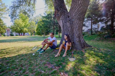 Baba ve kızı parkta birlikte zaman geçiriyorlar. Egzersiz yapıyor ve dinleniyorlar..