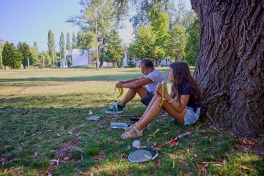 Baba ve kızı parkta birlikte zaman geçiriyorlar. Egzersiz yapıyor ve dinleniyorlar..