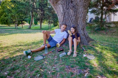 Baba ve kızı parkta birlikte zaman geçiriyorlar. Egzersiz yapıyor ve dinleniyorlar..