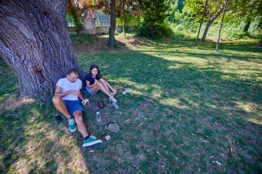 Baba ve kızı parkta birlikte zaman geçiriyorlar. Egzersiz yapıyor ve dinleniyorlar..