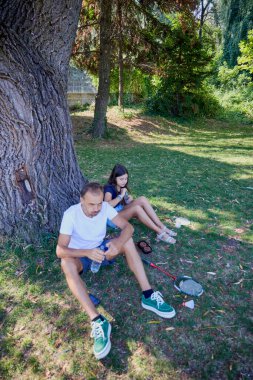Baba ve kızı parkta birlikte zaman geçiriyorlar. Egzersiz yapıyor ve dinleniyorlar..