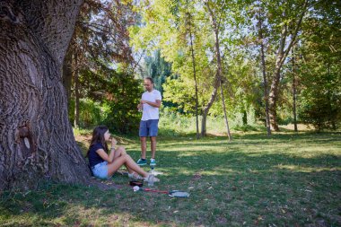 Baba ve kızı parkta birlikte zaman geçiriyorlar. Egzersiz yapıyor ve dinleniyorlar..