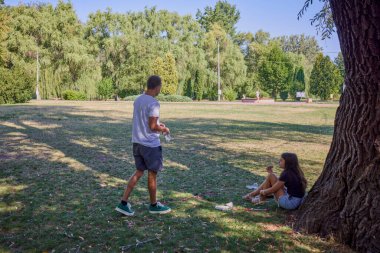 Baba ve kızı parkta birlikte zaman geçiriyorlar. Egzersiz yapıyor ve dinleniyorlar..