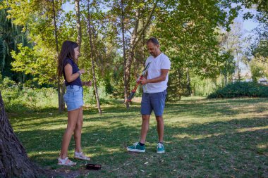 Baba ve kızı parkta birlikte zaman geçiriyorlar. Egzersiz yapıyor ve dinleniyorlar..