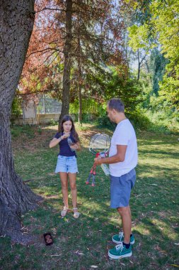 Baba ve kızı parkta birlikte zaman geçiriyorlar. Egzersiz yapıyor ve dinleniyorlar..