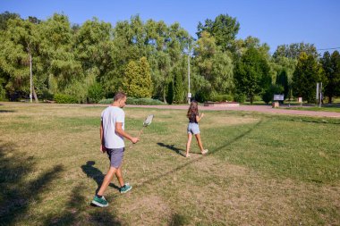 Baba ve kızı parkta birlikte zaman geçiriyorlar. Egzersiz yapıyor ve dinleniyorlar..