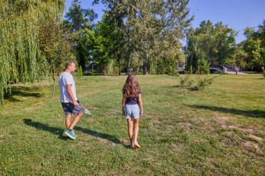 Baba ve kızı parkta birlikte zaman geçiriyorlar. Egzersiz yapıyor ve dinleniyorlar..