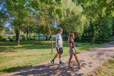 Baba ve kızı parkta birlikte zaman geçiriyorlar. Egzersiz yapıyor ve dinleniyorlar..