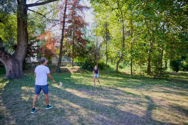 Baba ve kızı parkta birlikte zaman geçiriyorlar. Egzersiz yapıyor ve dinleniyorlar..