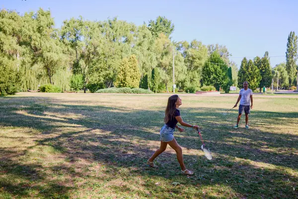Baba ve kızı parkta birlikte zaman geçiriyorlar. Egzersiz yapıyor ve dinleniyorlar..