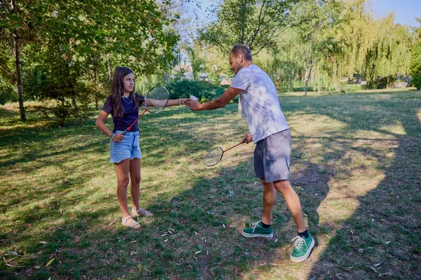 Baba ve kızı parkta birlikte zaman geçiriyorlar. Egzersiz yapıyor ve dinleniyorlar..