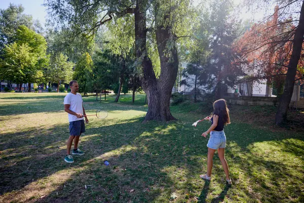 Baba ve kızı parkta birlikte zaman geçiriyorlar. Egzersiz yapıyor ve dinleniyorlar..