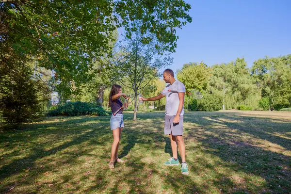 Baba ve kızı parkta birlikte zaman geçiriyorlar. Egzersiz yapıyor ve dinleniyorlar..