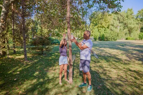 Baba ve kızı parkta birlikte zaman geçiriyorlar. Egzersiz yapıyor ve dinleniyorlar..
