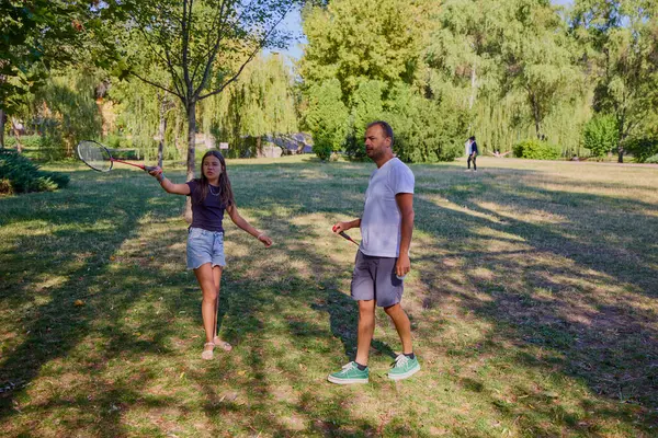 Baba ve kızı parkta birlikte zaman geçiriyorlar. Egzersiz yapıyor ve dinleniyorlar..