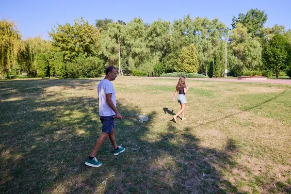 Baba ve kızı parkta birlikte zaman geçiriyorlar. Egzersiz yapıyor ve dinleniyorlar..