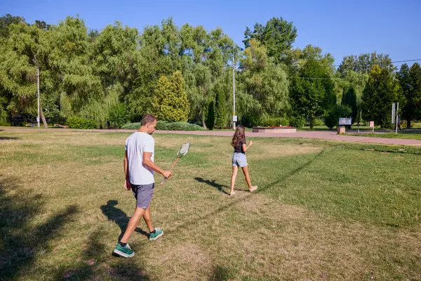 Baba ve kızı parkta birlikte zaman geçiriyorlar. Egzersiz yapıyor ve dinleniyorlar..