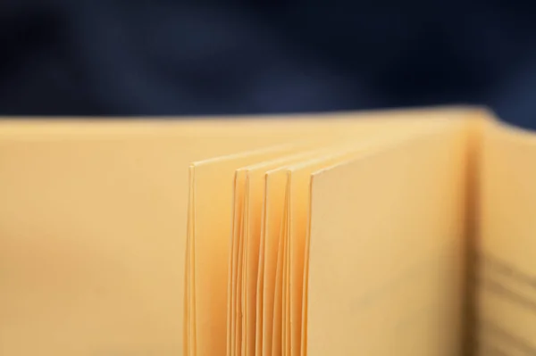 uncut pages of a small new book printed on a yellow vintage style paper