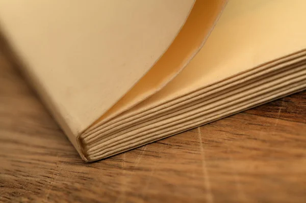 uncut pages of a small new book printed on a yellow vintage style paper