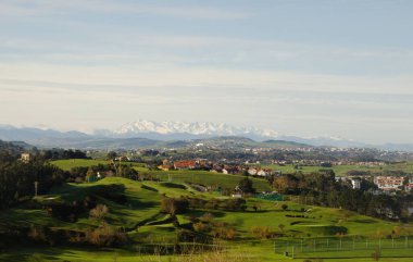 Cantabria, view inland over Liencres area, snow on Picos de Europa mountain range clipart