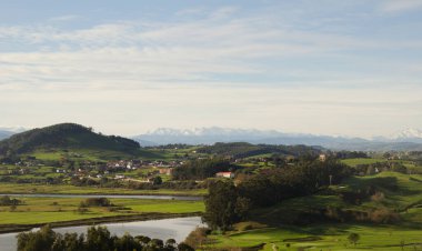 Cantabria, view inland over Liencres area, snow on Picos de Europa mountain range clipart
