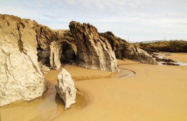 Cantabria, küçük dalgalı plaj Playa del Bocal, açık kum ve aşınmış kaya kayalıkları 