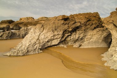 Cantabria, küçük dalgalı plaj Playa del Bocal, açık kum ve aşınmış kaya kayalıkları 