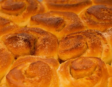 Yeni yapılmış tarçınlı çörek tepsisi, makro gıda arka planı.