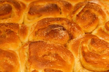 Yeni yapılmış tarçınlı çörek tepsisi, makro gıda arka planı.