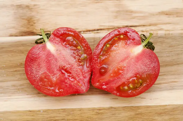 圆形粉红番茄 有鼻孔 在切成两半时可产生心形 图库照片