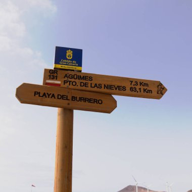 Playa del Burrero, Gran Canaria, İspanya - 2 Temmuz 2024: GR 131 için bir işaret, Sendero de gran record Adanın güneydoğu ve kuzeybatı kıyılarını birbirine bağlayan uzun mesafeli yürüyüş yolları yolun bir ucunda sergilenmektedir.