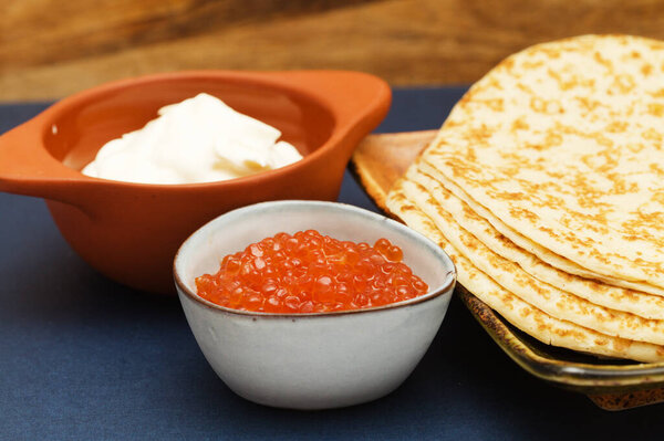 Orange salted salmon roe in a small triangular blue bowl