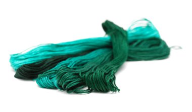 Pamuk işlemeli iplikler farklı renklerde, beyaz arkaplanda izole edilmiş.